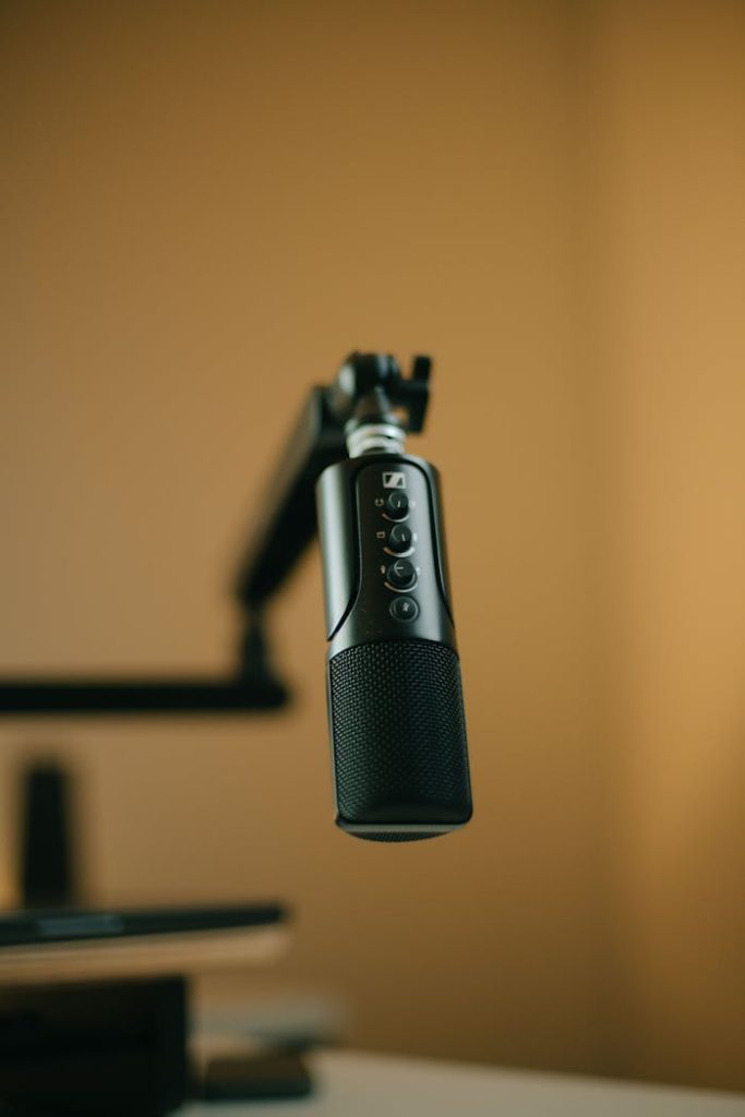 pexels photo 31236088 1 Close-up of a studio microphone setup with a boom arm in warm lighting.